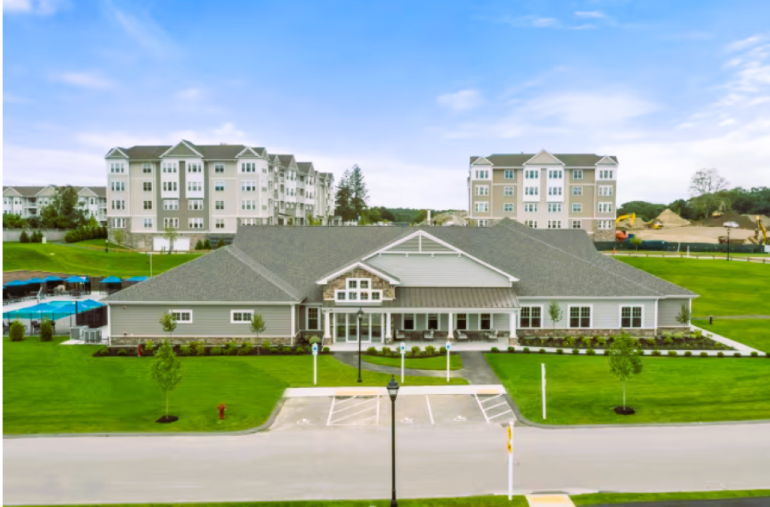 An aerial view of a large house with a large building in the background.