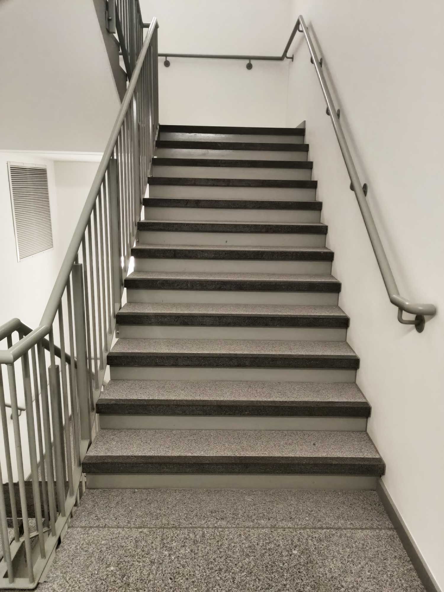 A black and white photo of a set of stairs with a railing