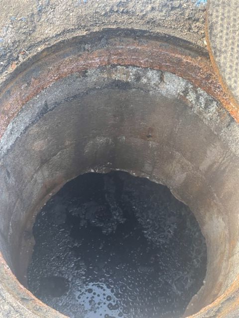 a manhole cover is open and filled with water .