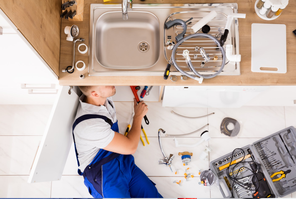 a plumber is fixing a sink in a kitchen