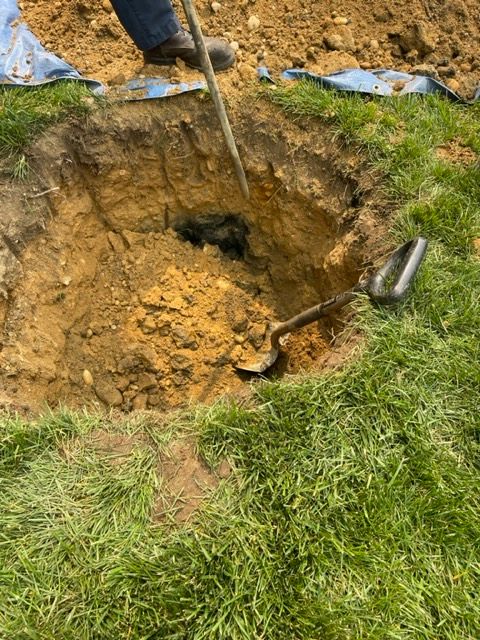 a person is digging a hole in the ground with a shovel.