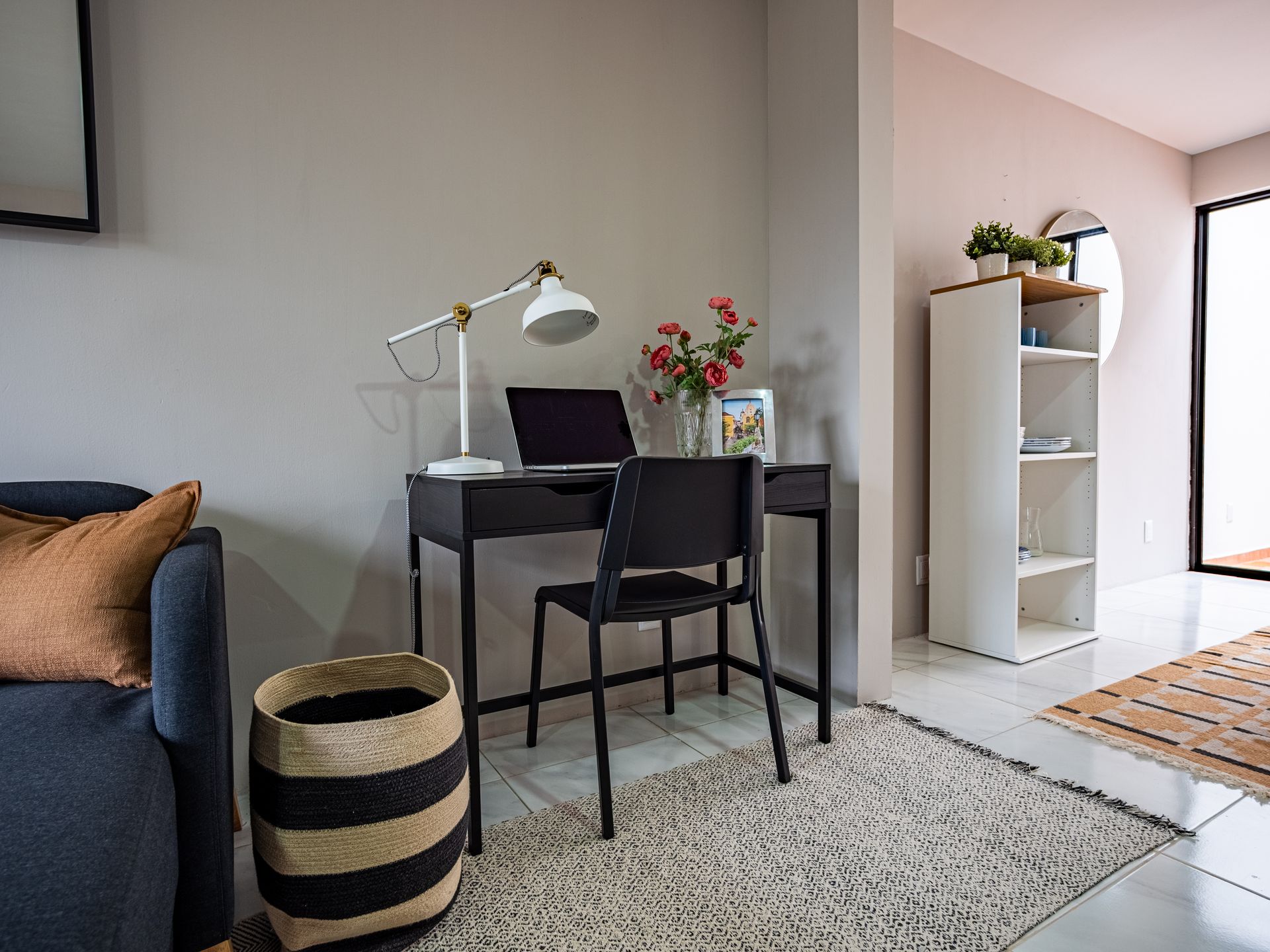 Una sala de estar con un escritorio y una silla con una computadora portátil encima.