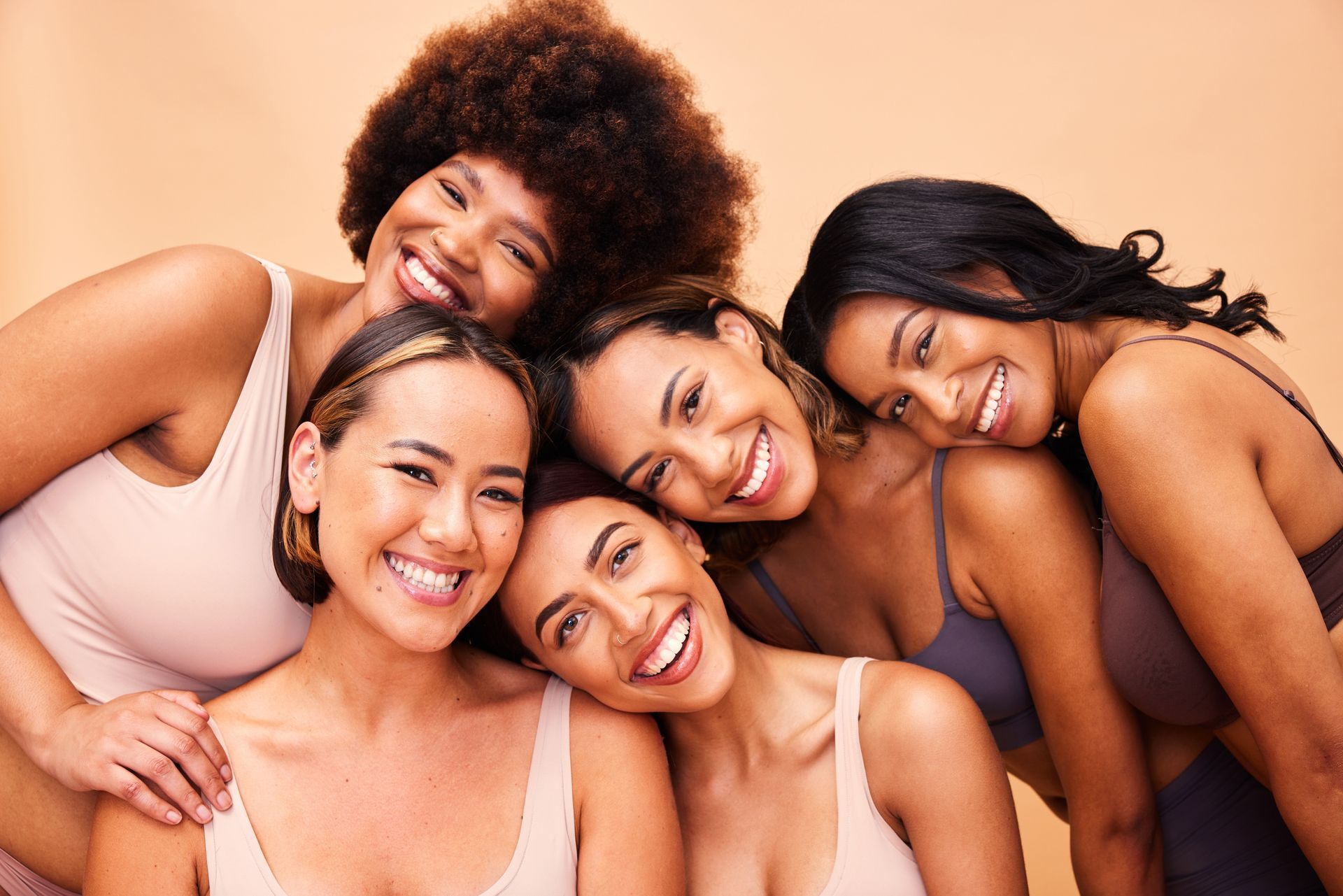 A group of women are posing for a picture together and smiling.