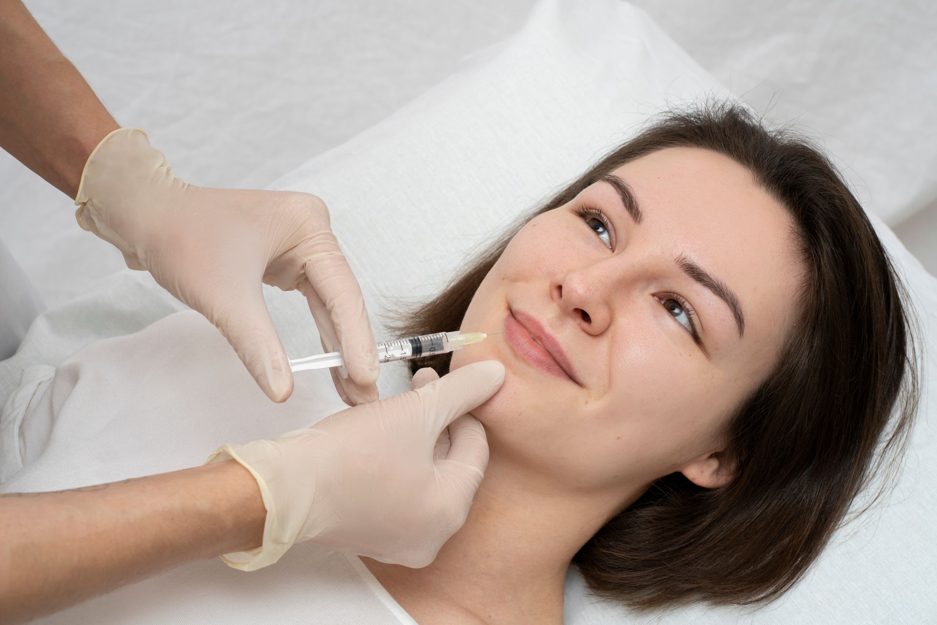 A woman is getting a botox injection in her face.