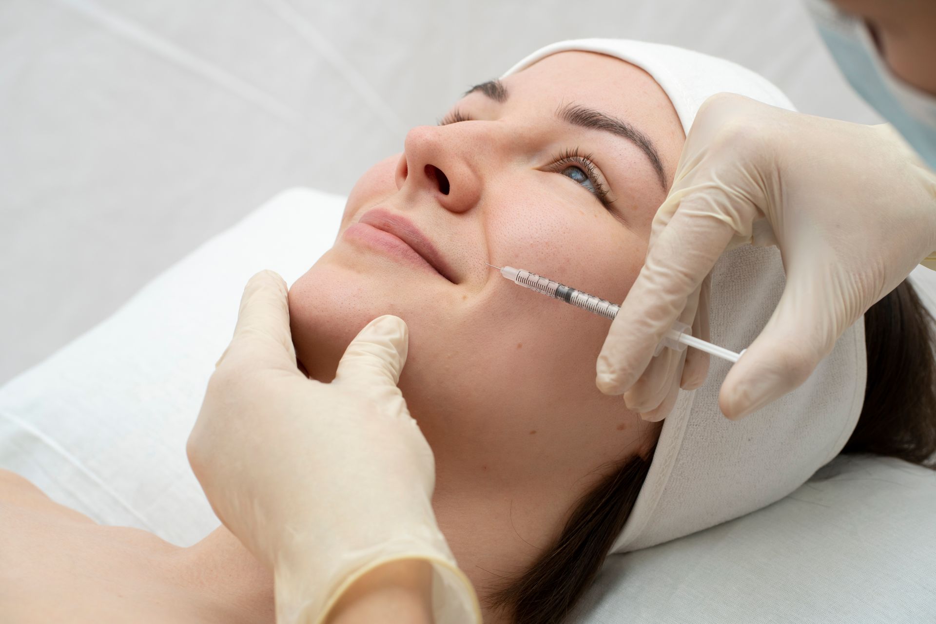 A woman is getting a botox injection in her face.