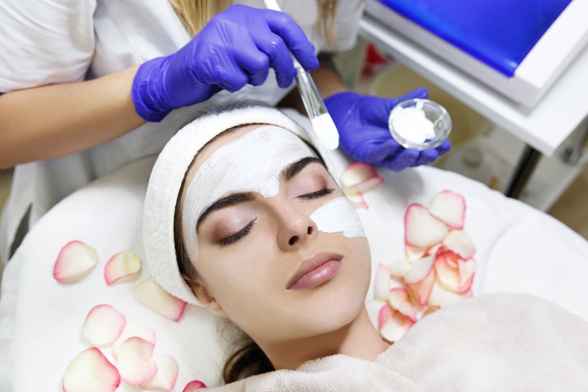 A woman is getting a facial treatment at a beauty salon.