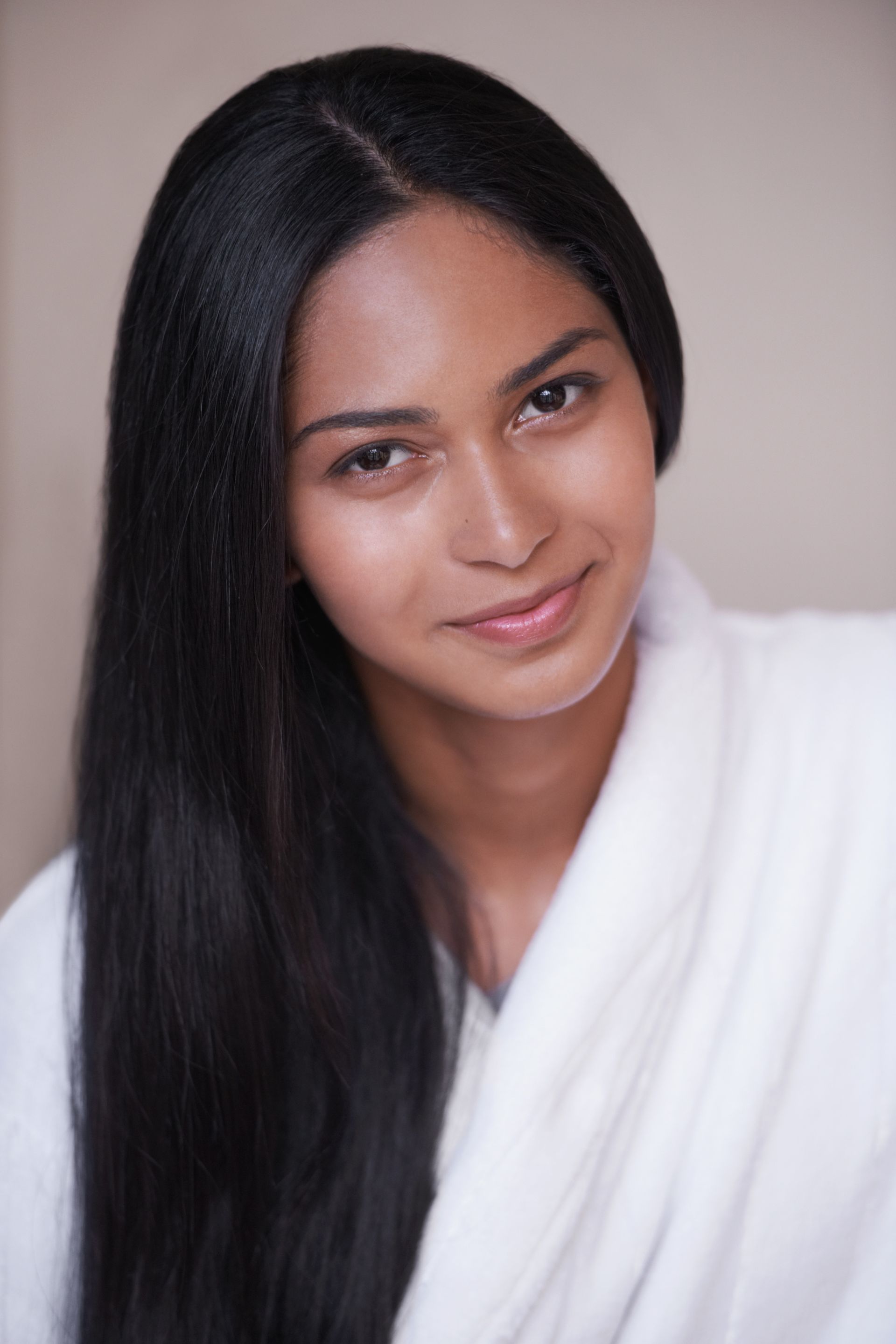 A woman with long black hair is wearing a white robe