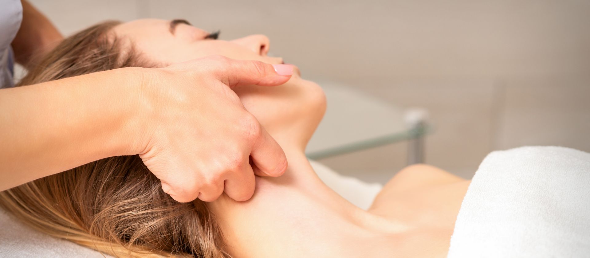 A woman is getting a facial massage at a spa.