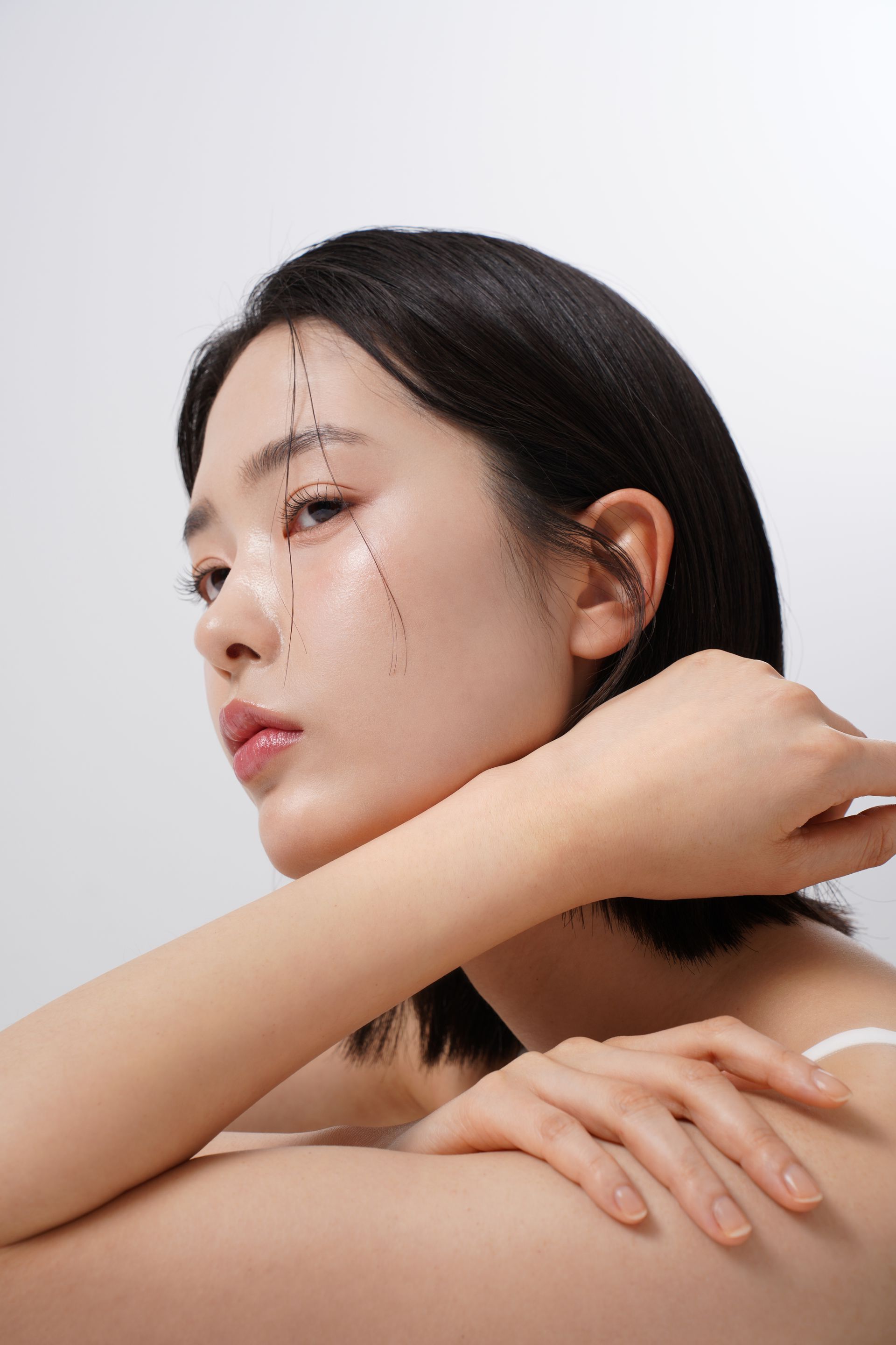 A close up of a woman 's face with her hand on her shoulder.