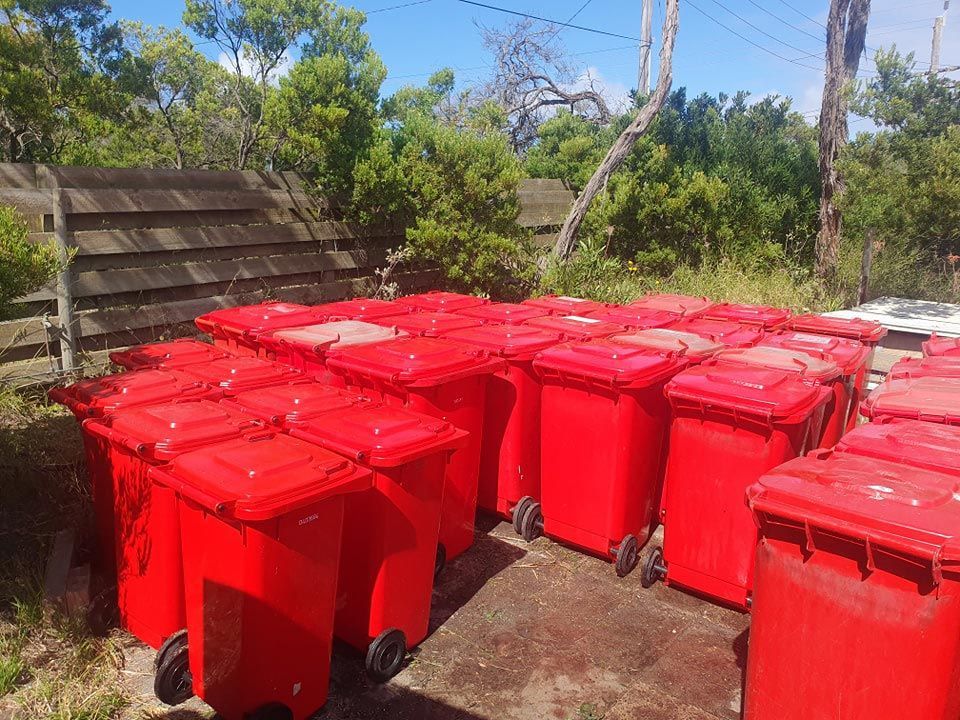 A Bunch Of Red Trash Cans Are On The Ground — Bin in a Bath in Saint Albans Park, VIC