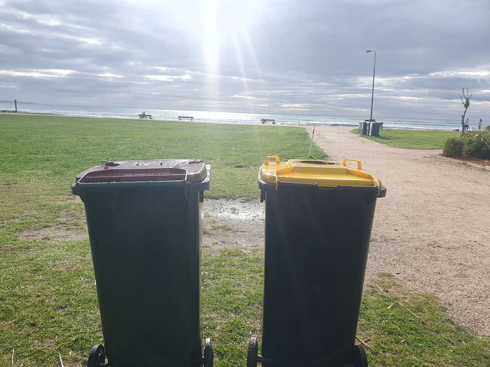 Two Trash Cans Are Sitting Next To Each Other In A Grassy Field — Bin in a Bath in Saint Albans Park, VIC