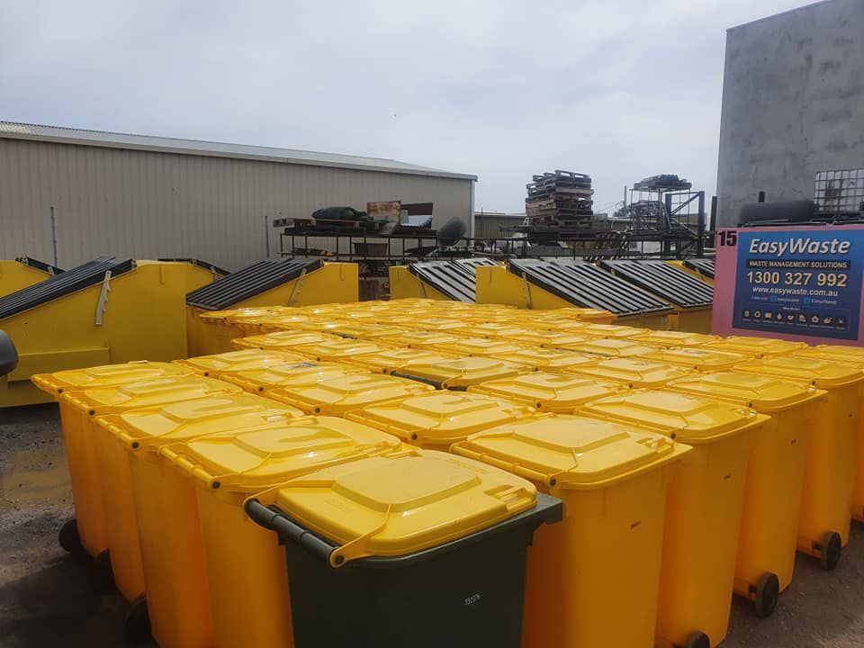 A Bunch Of Yellow Trash Cans Are Stacked On Top Of Each Other In A Parking Lot — Bin in a Bath in Saint Albans Park, VIC