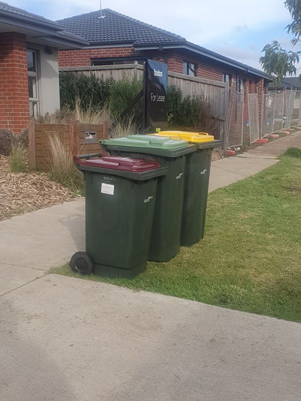 Three Trash Cans Are Lined Up On The Sidewalk In Front Of A House— Bin in a Bath in Saint Albans Park, VIC