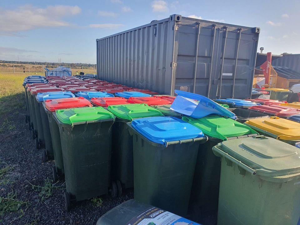 A Bunch Of Trash Cans Are Lined Up In Front Of A Shipping Container — Bin in a Bath in Saint Albans Park, VIC