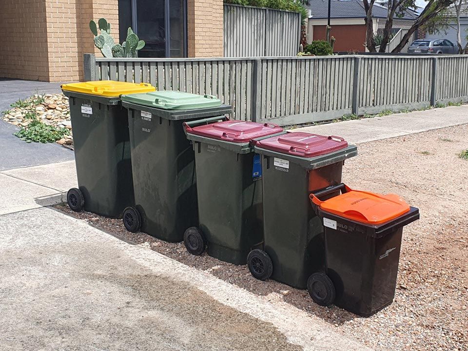 A Row Of Trash Cans Are Lined Up On The Side Of The Road — Bin in a Bath in Saint Albans Park, VIC
