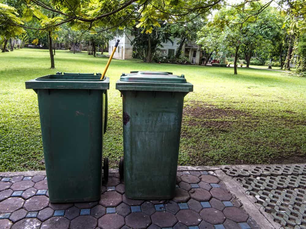 Two Green Trash Cans Are Sitting on a Sidewalk in a Park — Bin in a Bath in Melbourne, VIC