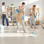 Three cleaners mopping a bright office space with shelves and cleaning supplies.