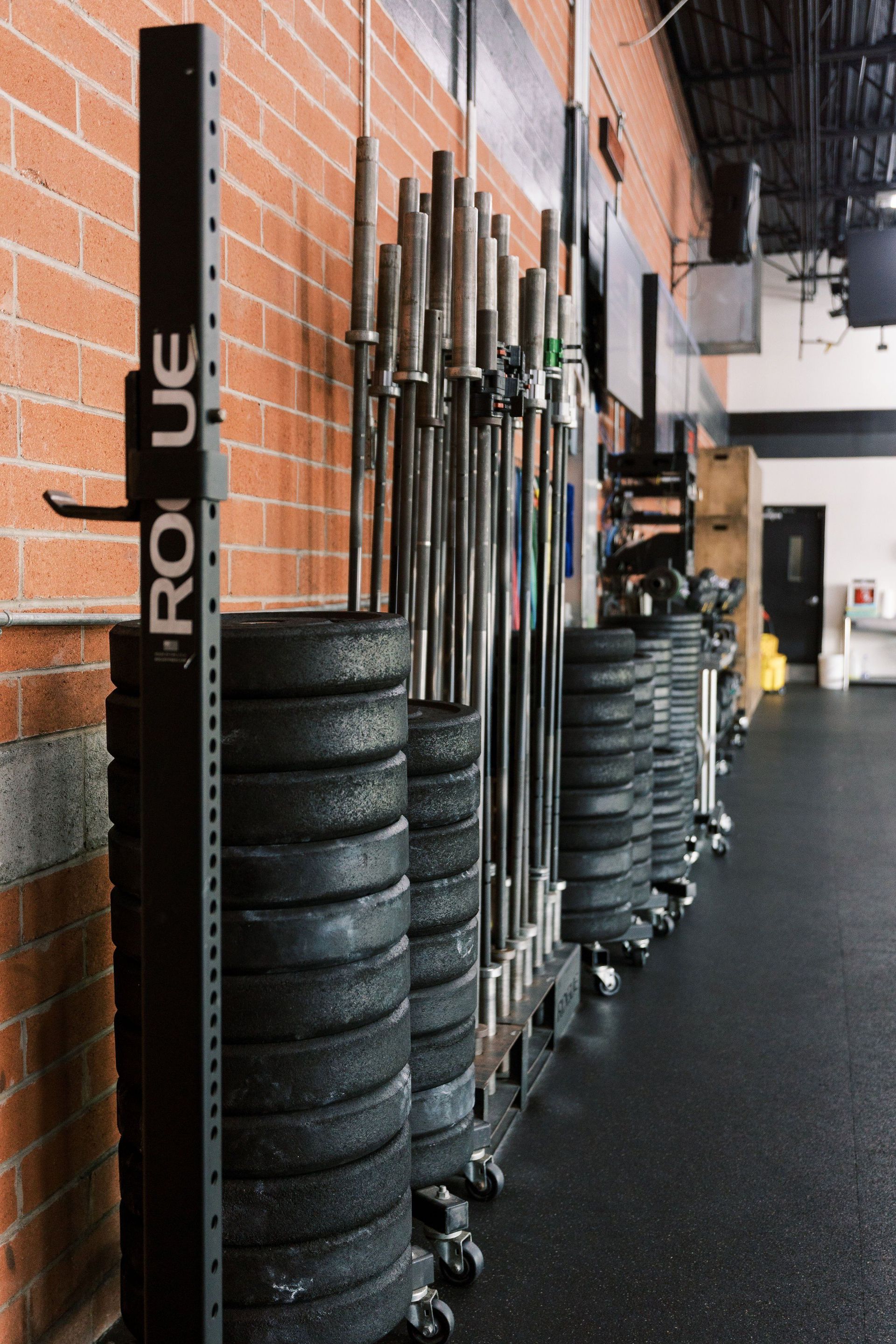 A row of barbells are stacked on top of each other in a gym.