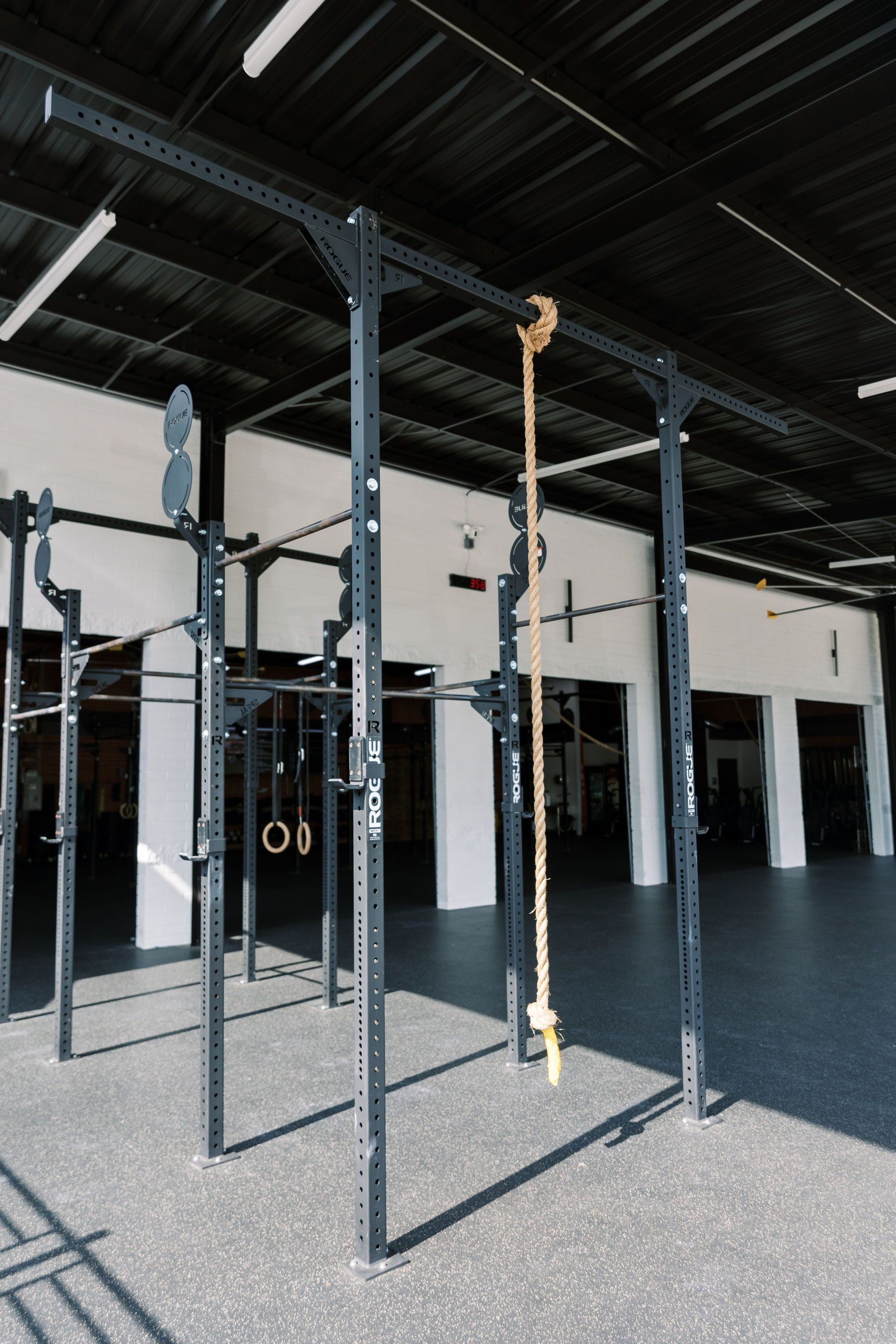 A gym with a rope hanging from the ceiling.