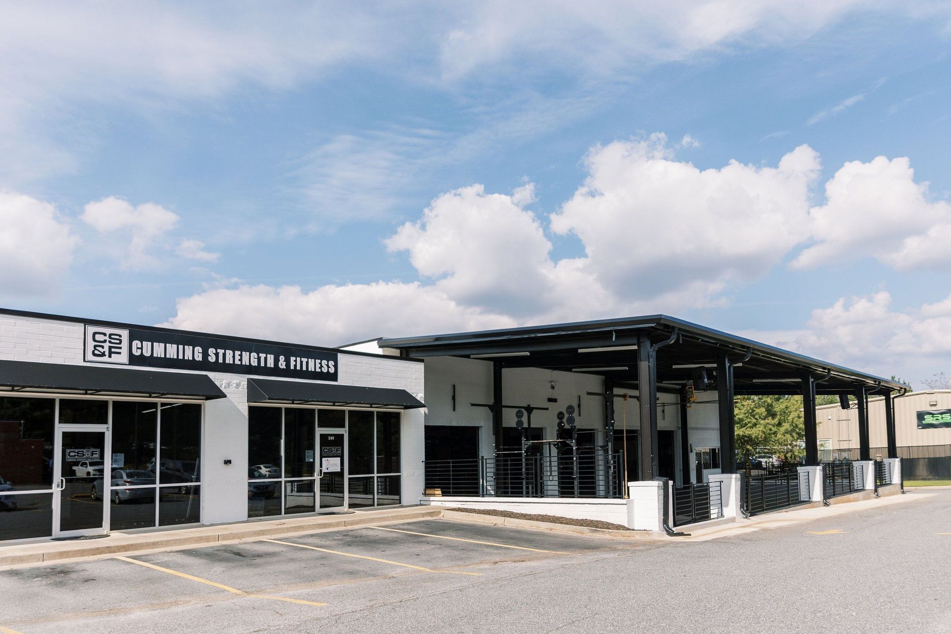 A large building with a lot of windows and a parking lot in front of it.