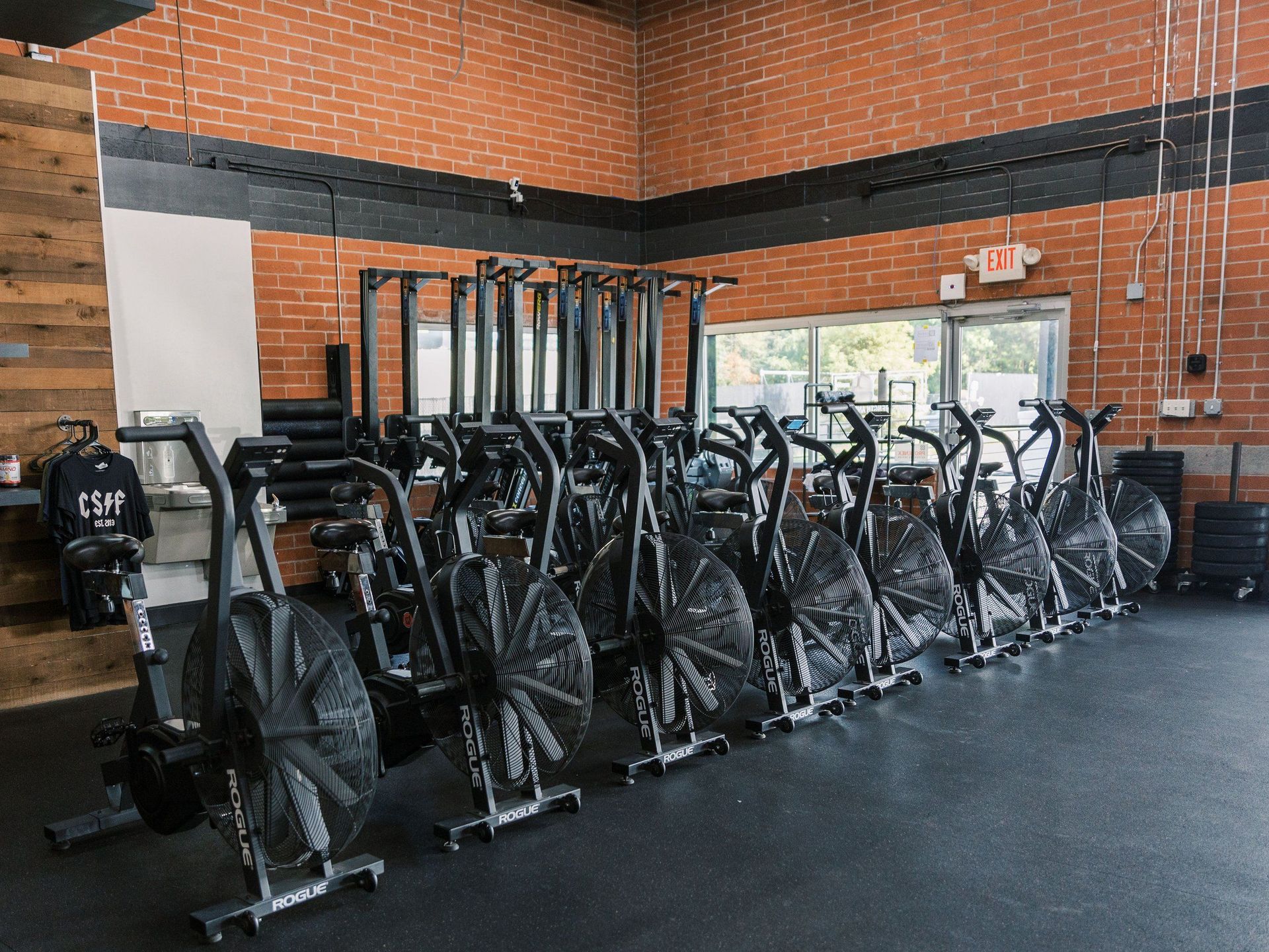 A row of exercise bikes are lined up in a gym.