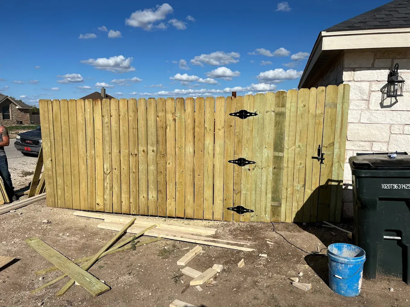 A wooden fence is being built in front of a house.