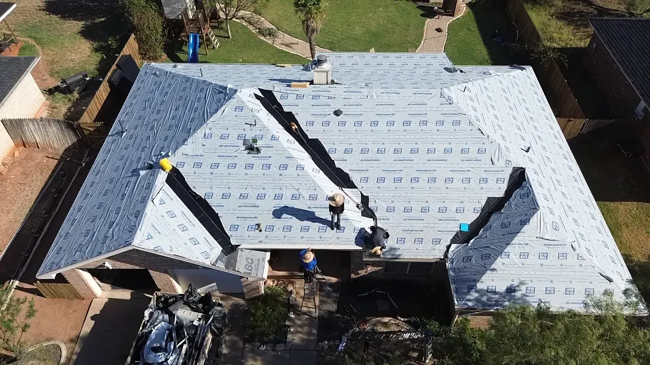 An aerial view of a roof being installed on a house.