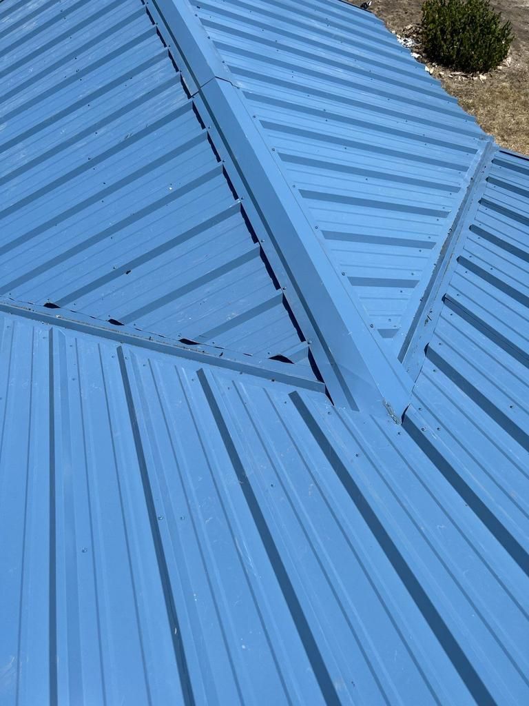 A close up of a blue metal roof on a house.