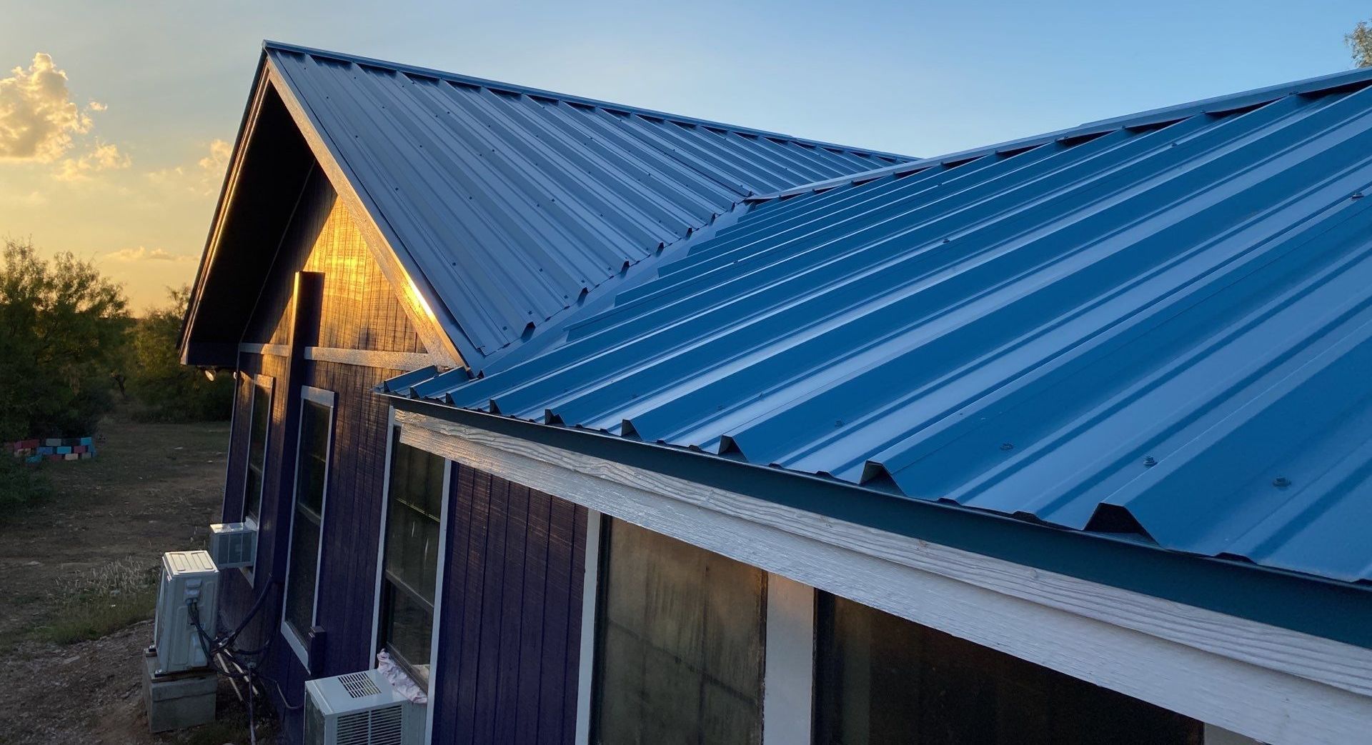 A blue metal roof is sitting on top of a purple house.