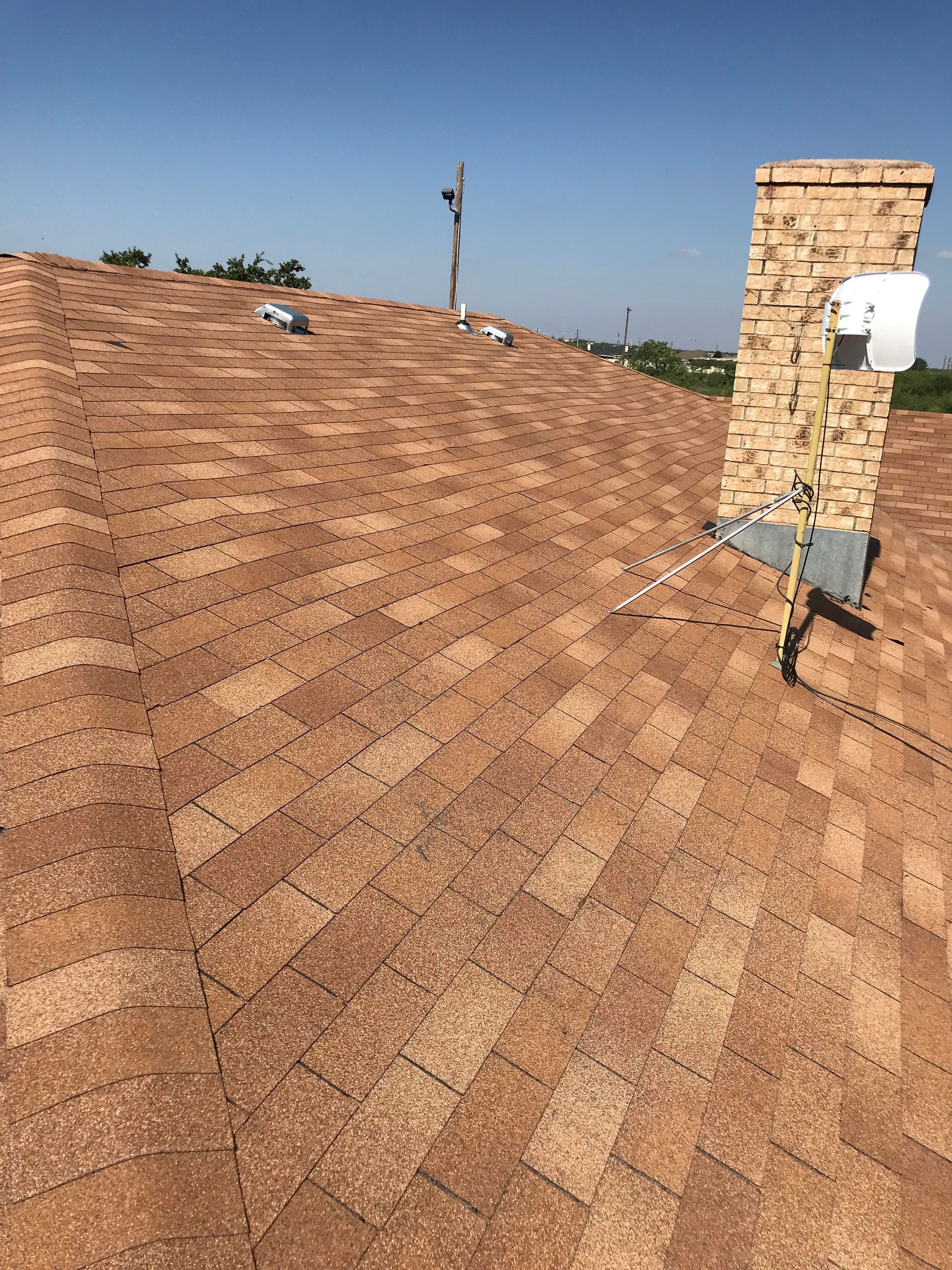 A roof with a chimney and a ladder on it