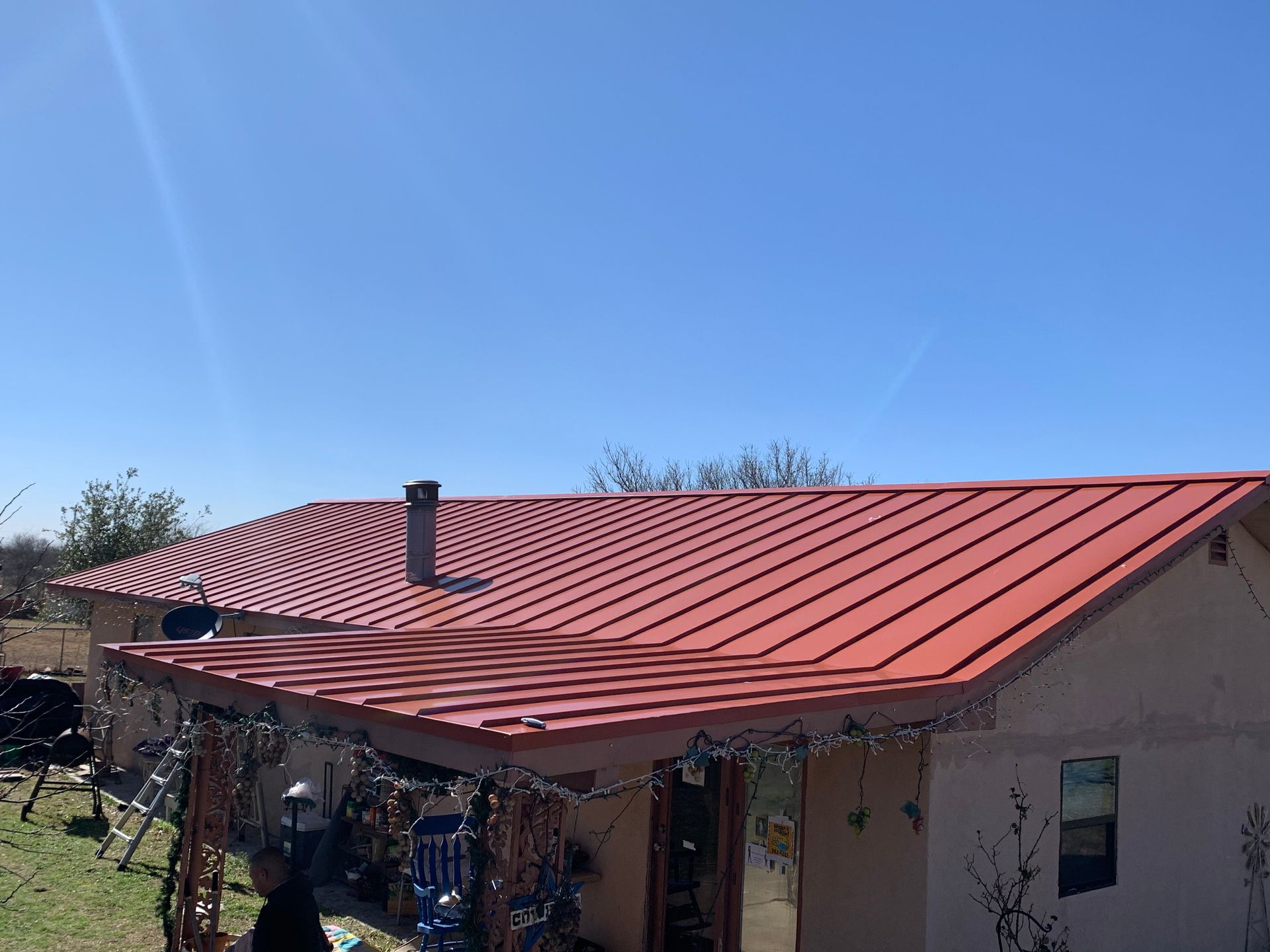 A house with a red roof and a blue sky in the background.