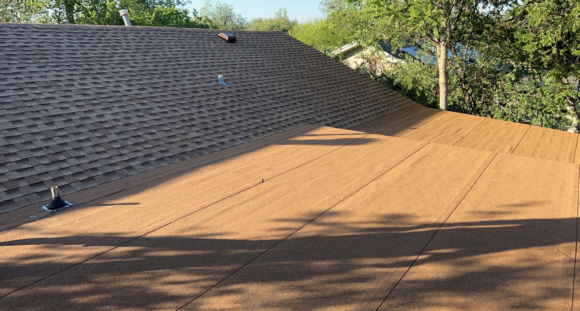 A large pile of dirt is sitting on top of a hill next to a brick wall.