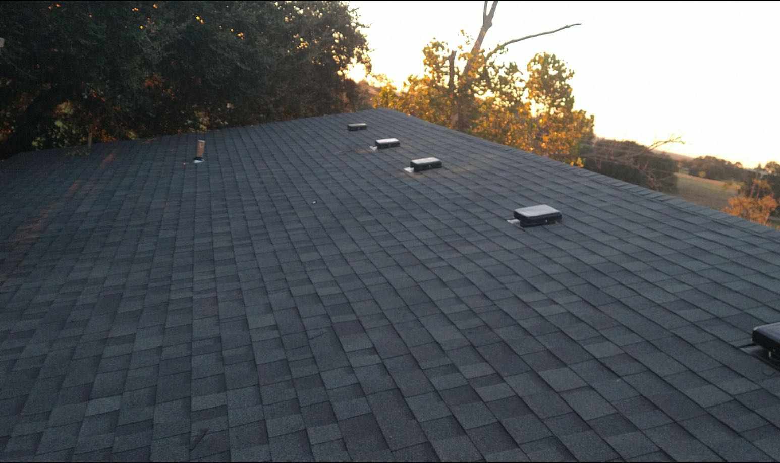 A roof with a lot of shingles and skylights on it