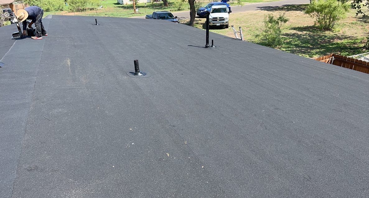 A man is working on a roof with a screwdriver.