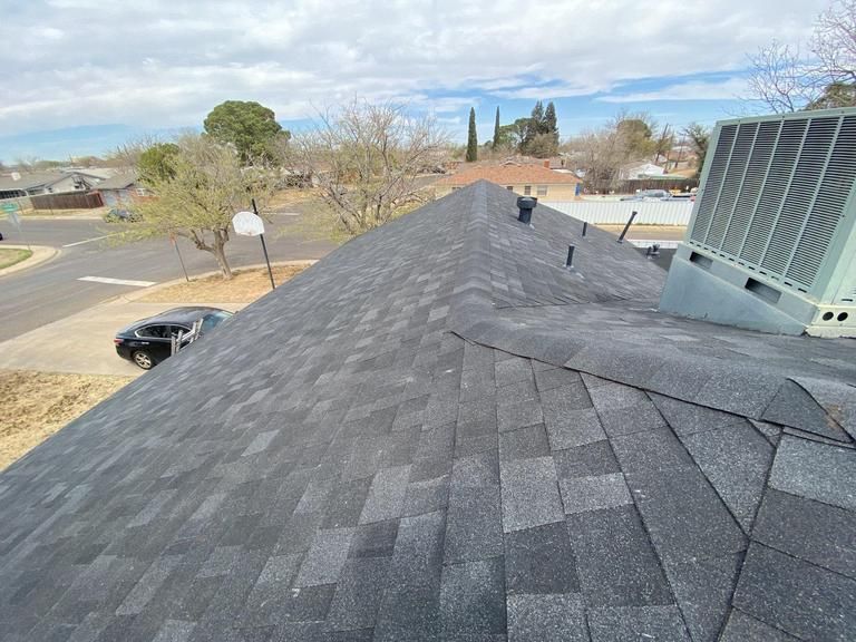 The roof of a house with a black car parked on it.