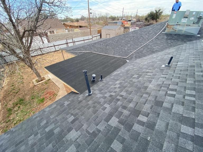 A man is standing on top of a roof.