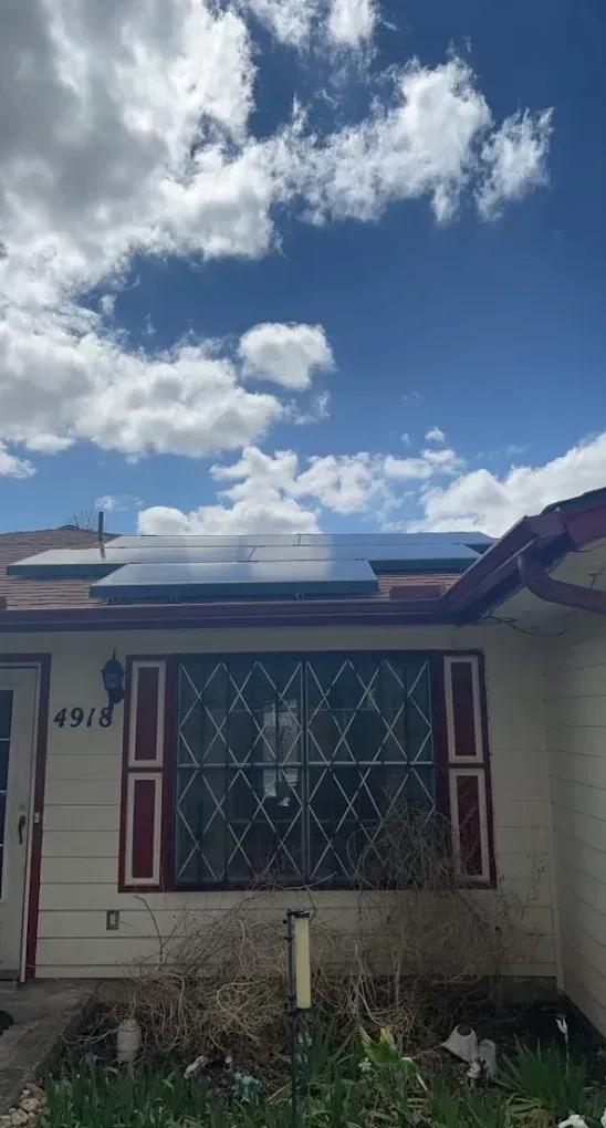A house with a solar panel on the roof.