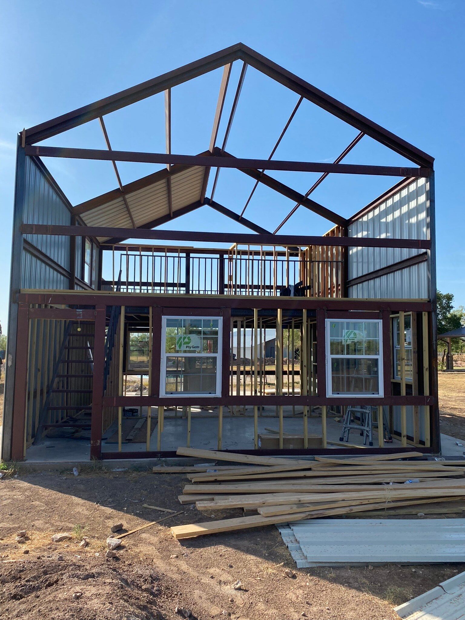 A house is being built in the middle of a dirt field.