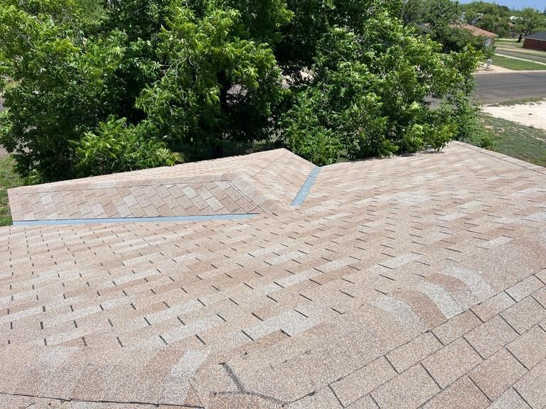 A brown roof with a tree in the background
