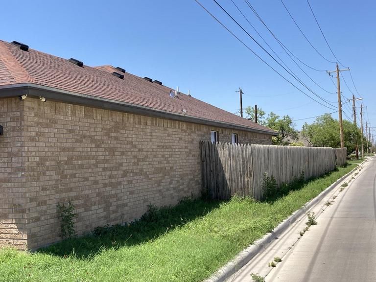 A brick building with a wooden fence in front of it