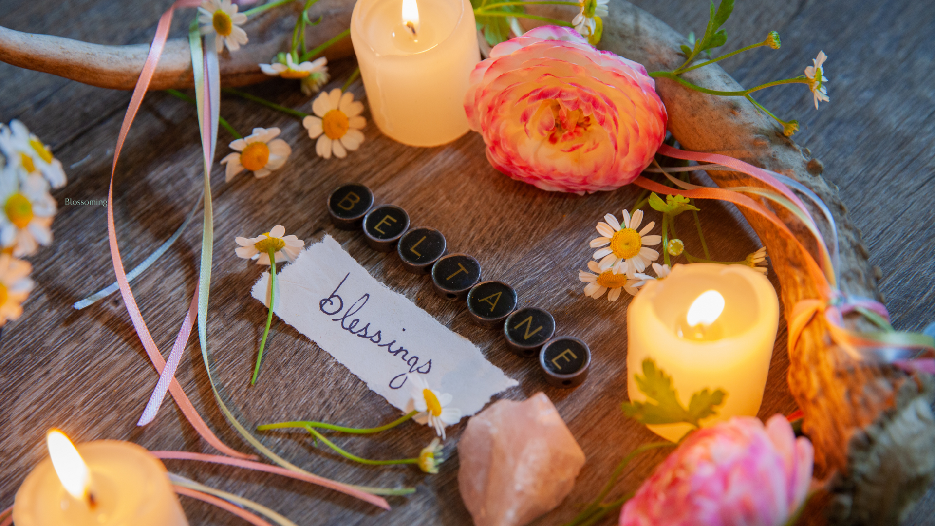 ritual altar with candles, pink ranunculus flowers, daisies, rose quartz, pastel ribbon