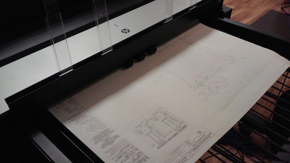 Blueprint on a large format scanner, black frame, white background.