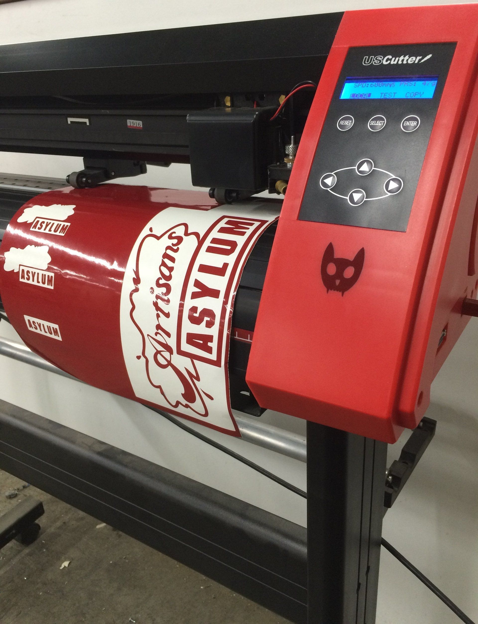 Red vinyl cutter with a cylindrical roll of red and white vinyl. 