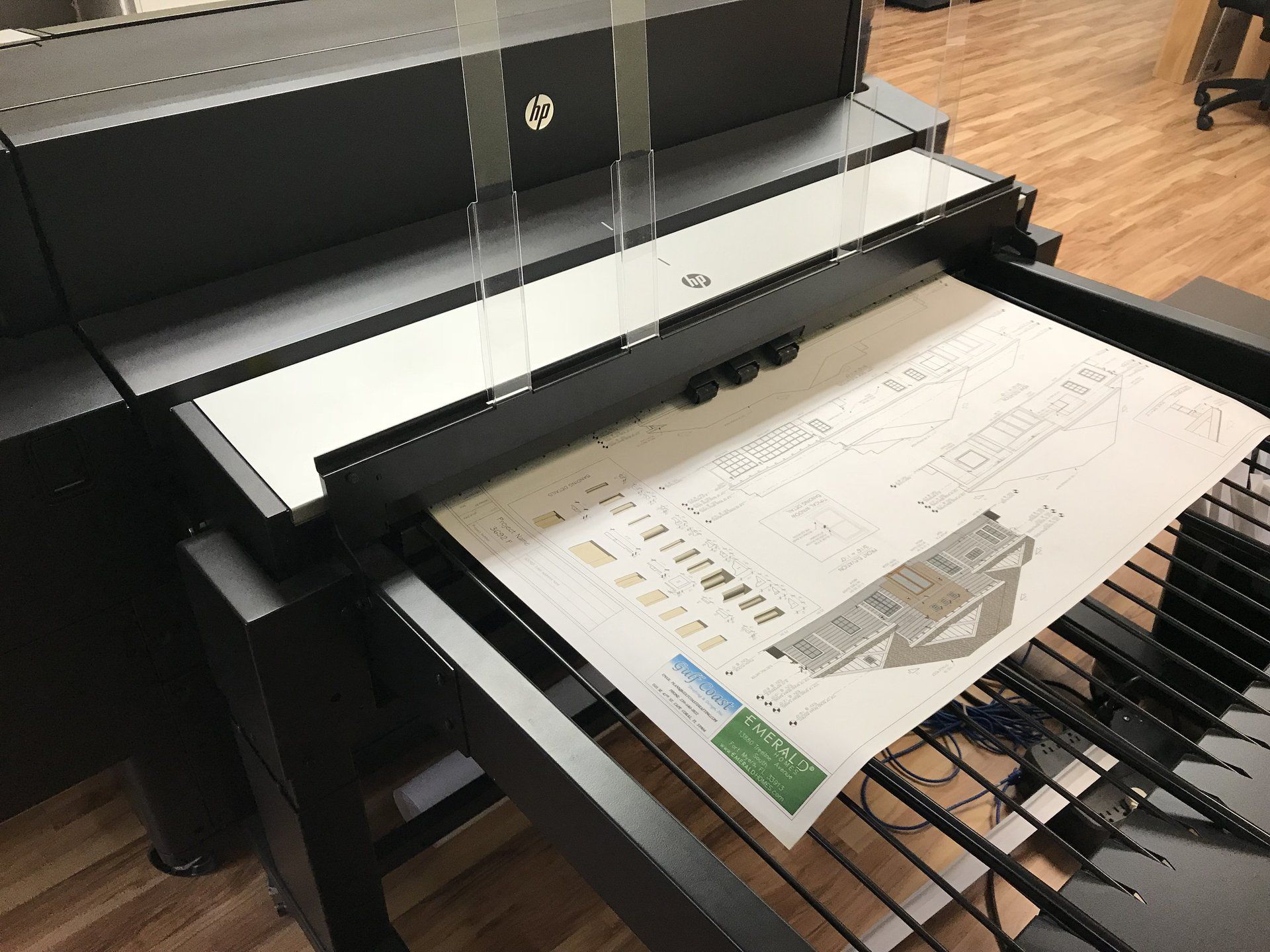 Large-format HP printer in a room, printing a colored architectural diagram.