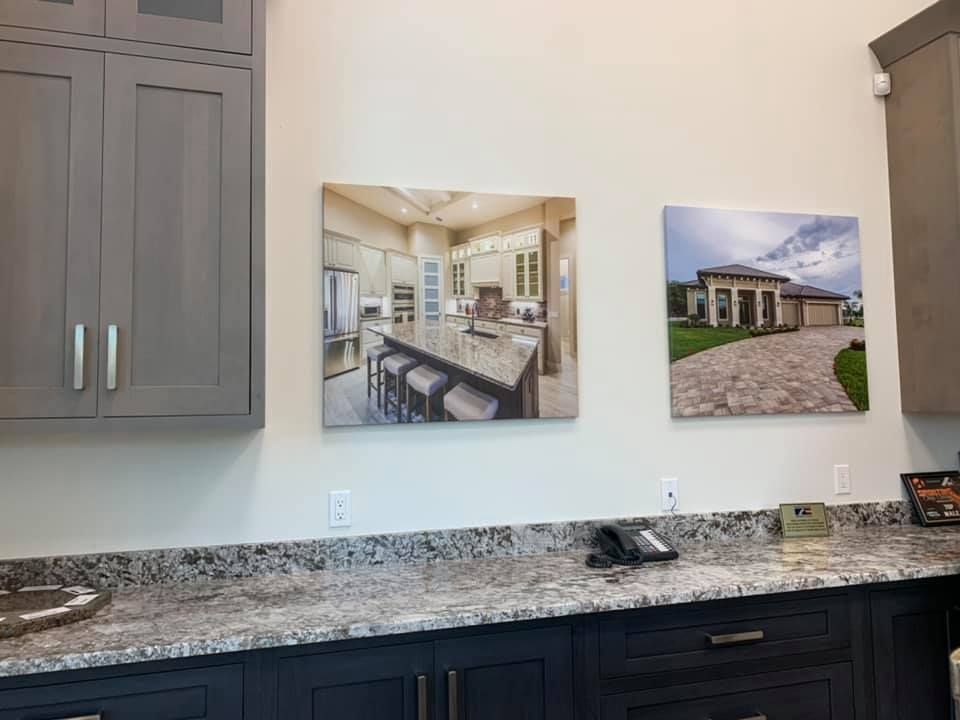 Kitchen display with cabinets, countertops, and photos of a house and kitchen.