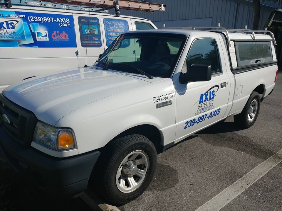 White Ford Ranger truck with company logo parked outdoors.