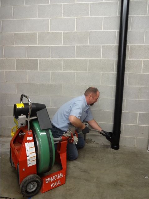 A person is cleaning a septic tank with a hose.