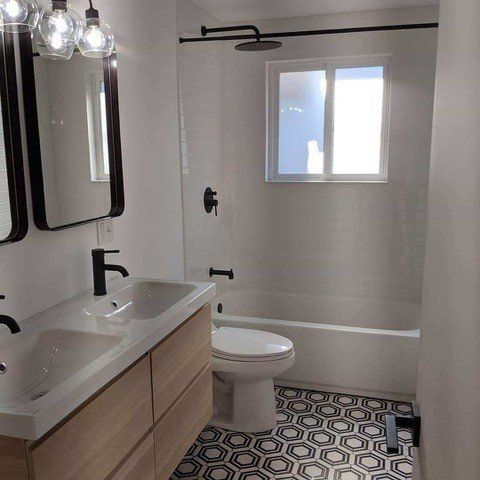 A bathroom with a sink , toilet , bathtub and mirror.