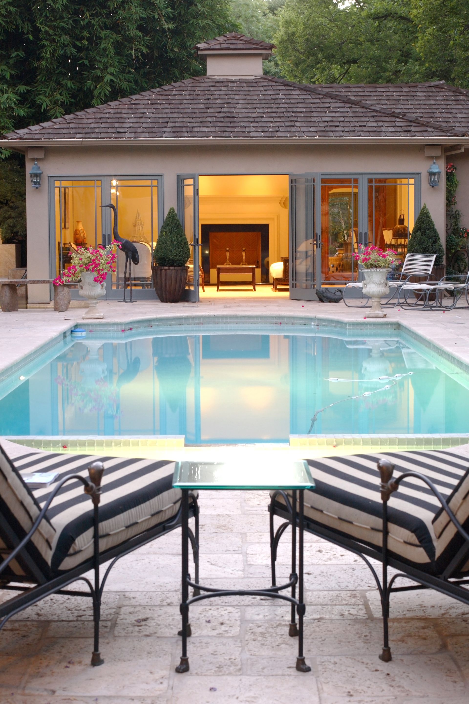 A house with a large swimming pool in front of it