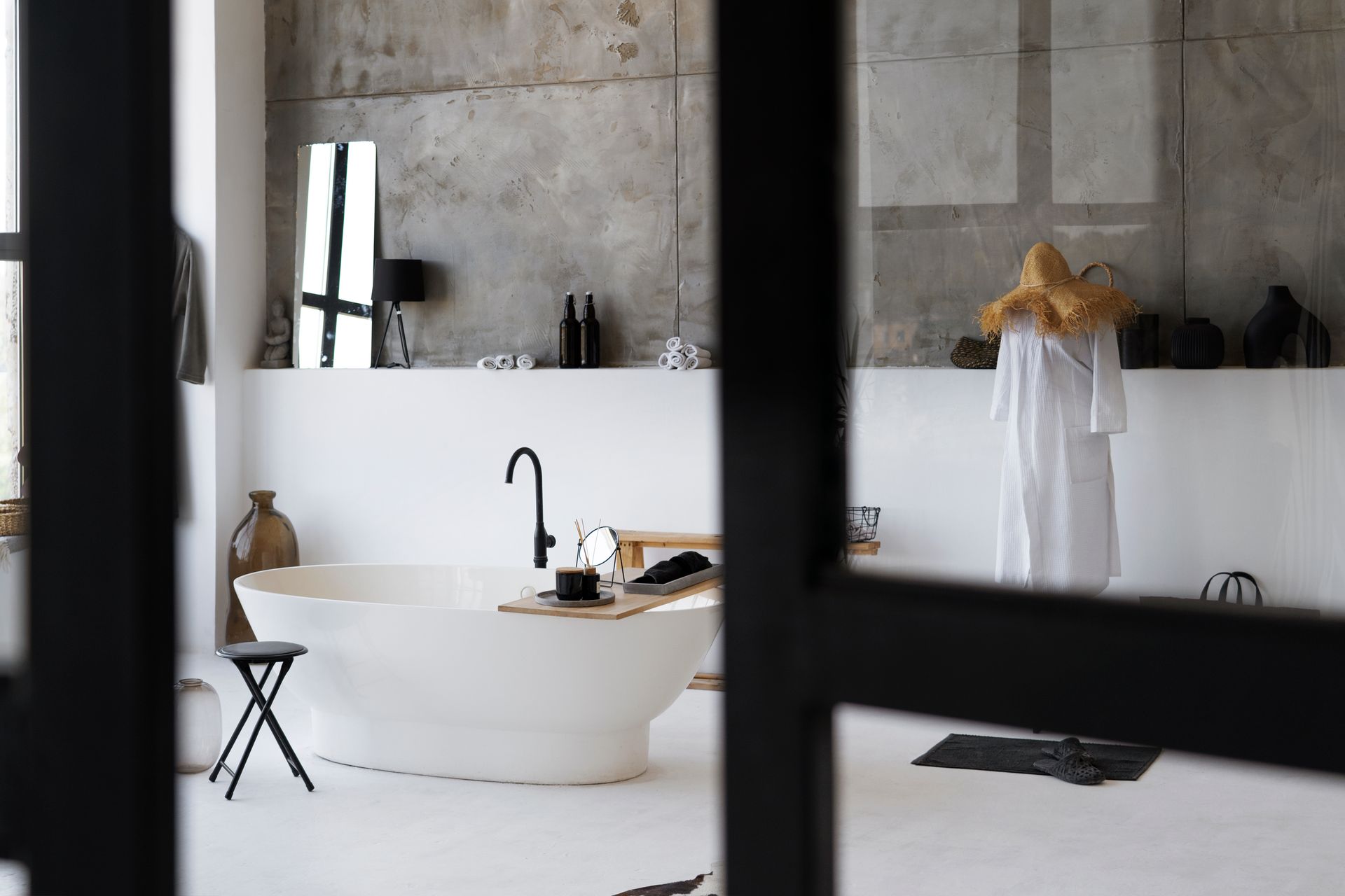 A bathroom with a white bathtub and a black faucet.